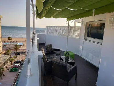 a balcony with chairs and a view of the beach at ÁTICO VICTORIA BEACH in Cádiz