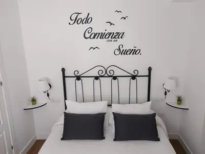 a bedroom with a bed with a sign that reads job commnesia and a answer at ÁTICO VICTORIA BEACH in Cádiz