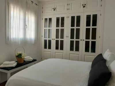 a bedroom with white cabinets and a white bed at ÁTICO VICTORIA BEACH in Cádiz