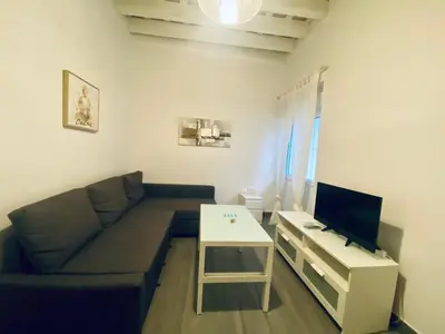 a living room with a couch and a table with a tv at La Posada de Sacramento Grupo AC Gestion in Cádiz
