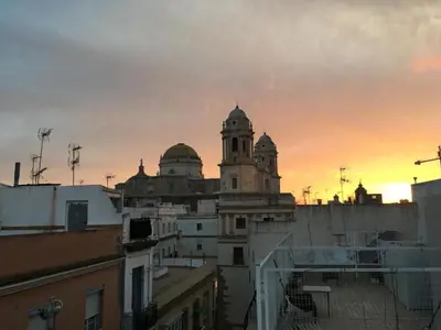 a view of a building with a sunset in the background at La Posada de Sacramento Grupo AC Gestion in Cádiz