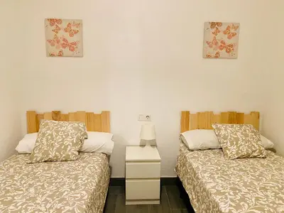 a bedroom with two beds and a nightstand and two pictures at La Posada de Sacramento Grupo AC Gestion in Cádiz