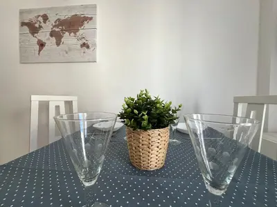 a table with two glass vases and a plant on it at El Sardinero in Chipiona