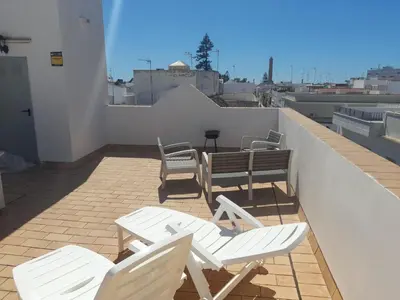 a patio with chairs and a table on a roof at El Sardinero in Chipiona