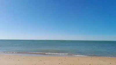 a sandy beach with the ocean in the background at El Sardinero in Chipiona