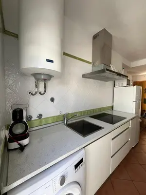 a kitchen with a sink and a stove top oven at El Sardinero in Chipiona