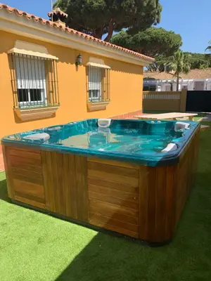 a hot tub in a yard next to a house at Chiclana casa maría in Chiclana de la Frontera