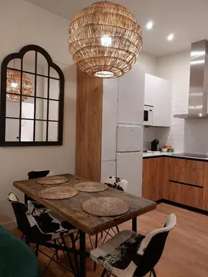 a kitchen with a table with chairs and a large chandelier at Hidden Gem Pasquin Suites in Mercado Central in Cádiz