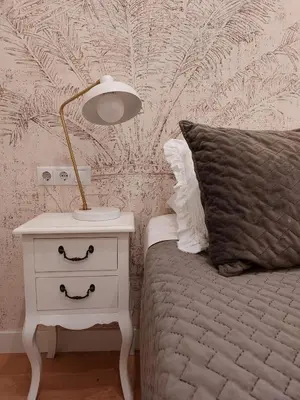 a bedroom with a bed and a lamp on a night stand at Hidden Gem Pasquin Suites in Mercado Central in Cádiz