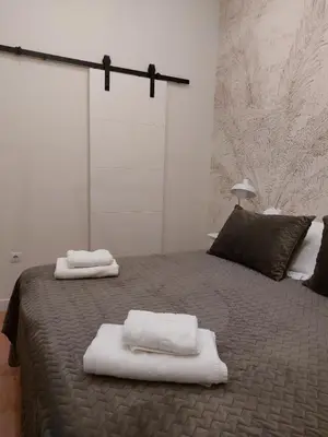 a bedroom with a bed with towels on it at Hidden Gem Pasquin Suites in Mercado Central in Cádiz