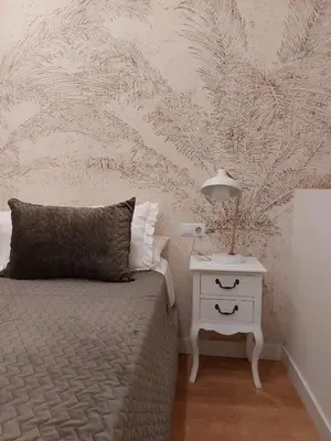 a bedroom with a bed and a night stand with a nightstand at Hidden Gem Pasquin Suites in Mercado Central in Cádiz