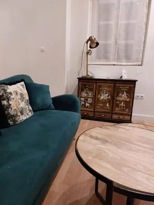 a living room with a green couch and a table at Hidden Gem Pasquin Suites in Mercado Central in Cádiz