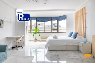 a white bedroom with a bed and a desk at Loft Victoria Beach - FREE PARKING by Cadiz Time in Cádiz