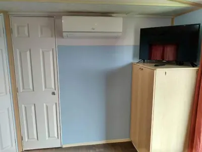 a room with a television and a closet with a door at Residencial Robles in Sanlúcar de Barrameda