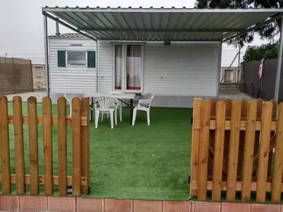 a backyard with a table and chairs and a fence at Residencial Robles in Sanlúcar de Barrameda