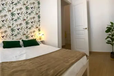 a bedroom with a large bed with green pillows at GATU PREMIUM Villa Libertad in Cádiz