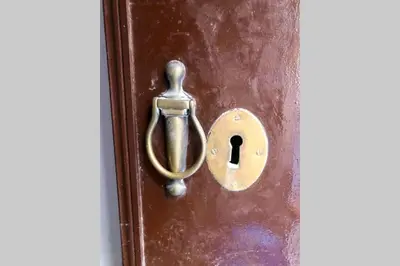 a bronze door knob on a wooden door at GATU PREMIUM Villa Libertad in Cádiz