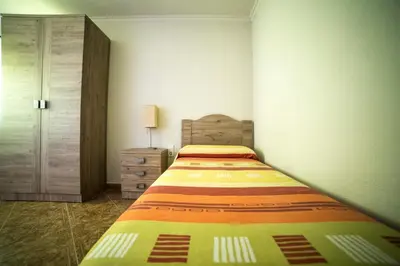 a small bedroom with a bed and a dresser at Cerquita de la Caleta by Gades Gestión in Cádiz