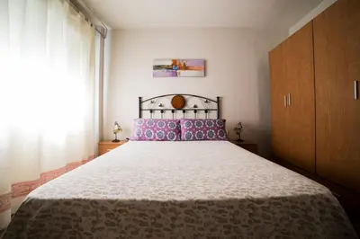 a bedroom with a large bed with pink pillows at Cerquita de la Caleta by Gades Gestión in Cádiz