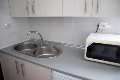 a kitchen counter with a sink and a microwave at Cerquita de la Caleta by Gades Gestión in Cádiz
