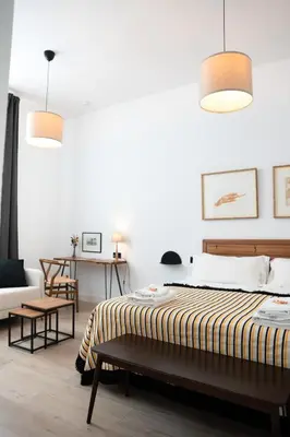 a bedroom with a bed and two pendant lights at Casa Miguel - Apartamento 1 in Sanlúcar de Barrameda