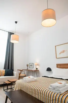 a white room with a bed and a table at Casa Miguel - Apartamento 1 in Sanlúcar de Barrameda