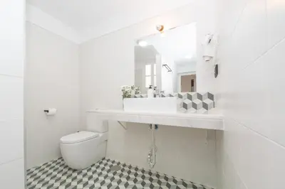 a white bathroom with a sink and a toilet at Casa Miguel - Apartamento 1 in Sanlúcar de Barrameda
