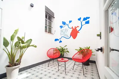 a room with two red chairs and plants at Casa Miguel - Apartamento 1 in Sanlúcar de Barrameda