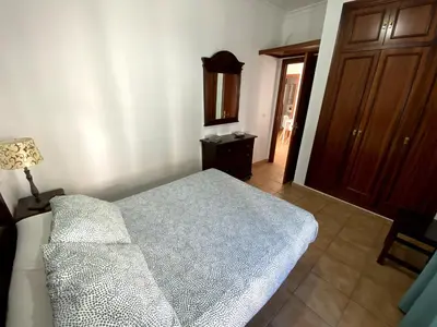 a bedroom with a bed and a lamp and a door at Apartamento Hostal Mellizo in Lebrija