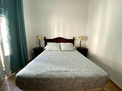 a bedroom with a bed and two lamps on tables at Apartamento Hostal Mellizo in Lebrija
