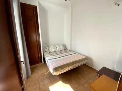 a small room with a bed in the corner of a room at Apartamento Hostal Mellizo in Lebrija