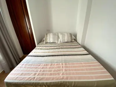 a bed with a striped mattress in a room at Apartamento Hostal Mellizo in Lebrija