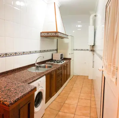a kitchen with a sink and a washing machine at Apartamento Hostal Mellizo in Lebrija