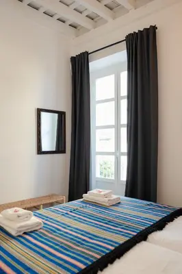 a bedroom with a bed with two towels on it at Casa Miguel - Apartamento 3 in Sanlúcar de Barrameda