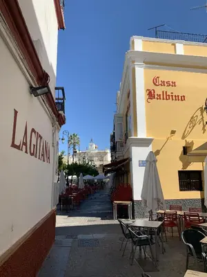 an empty street with tables and chairs and a building at Casa Miguel - Apartamento 2 in Sanlúcar de Barrameda
