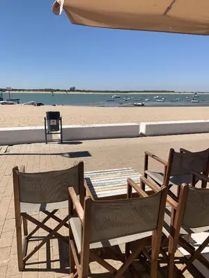 two chairs and a table on the beach at Casa Miguel - Apartamento 2 in Sanlúcar de Barrameda