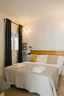 a bedroom with a large bed with two towels on it at Casa Miguel - Apartamento 4 in Sanlúcar de Barrameda