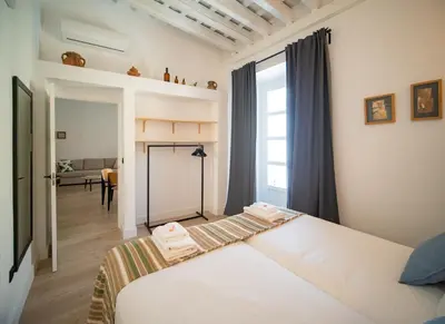 a bedroom with a white bed and a window at Casa Miguel - Apartamento 5 in Sanlúcar de Barrameda