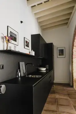 a kitchen with black cabinets and a black counter top at Casa Miguel - Apartamento 5 in Sanlúcar de Barrameda