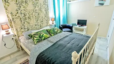 a bedroom with a bed and a desk with a laptop at Palacios Deluxe Apartment with Elevator in El Puerto de Santa María