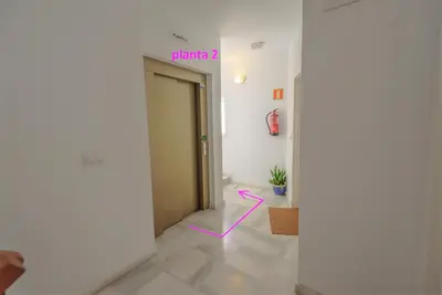 a hallway with a door with a pink arrow on it at Palacios Deluxe Apartment with Elevator in El Puerto de Santa María