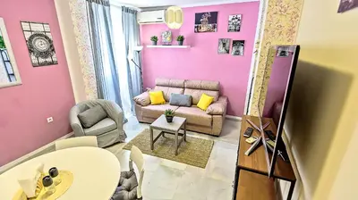 a pink living room with a couch and a table at Palacios Deluxe Apartment with Elevator in El Puerto de Santa María