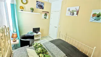 a bedroom with a bed and a desk with a computer at Palacios Deluxe Apartment with Elevator in El Puerto de Santa María