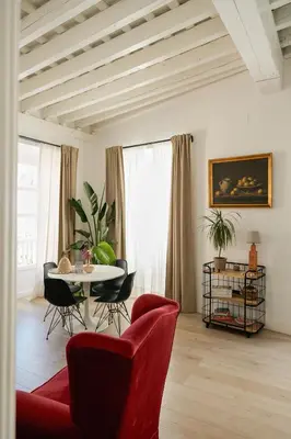 a living room with a red couch and a table at Casa Miguel - Apartamento 6 in Sanlúcar de Barrameda