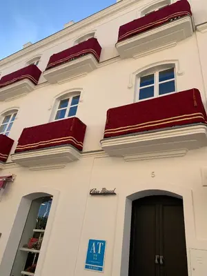 a white building with red roofs and a door at Casa Miguel - Apartamento 6 in Sanlúcar de Barrameda
