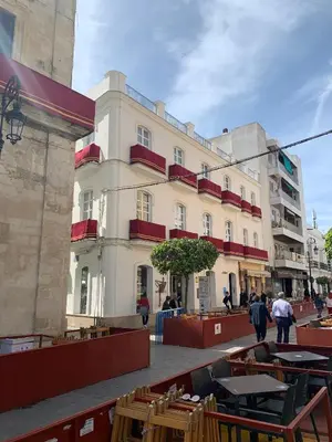a building with tables and chairs in front of it at Casa Miguel - Apartamento 6 in Sanlúcar de Barrameda