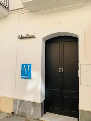 an entrance to a building with a black door at Casa Miguel - Apartamento 6 in Sanlúcar de Barrameda