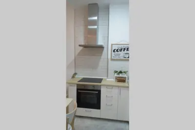 a kitchen with white cabinets and a stove top oven at El patio de San Isidro by Gades Gestión in Cádiz