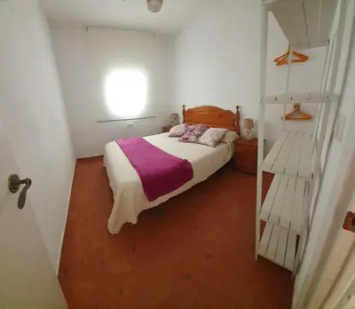 a small bedroom with a bed and a window at GirasolesV in Sanlúcar de Barrameda