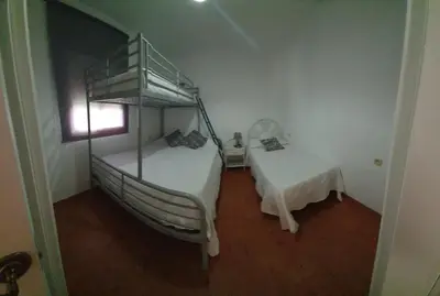 a bedroom with a bunk bed and a table at GirasolesV in Sanlúcar de Barrameda
